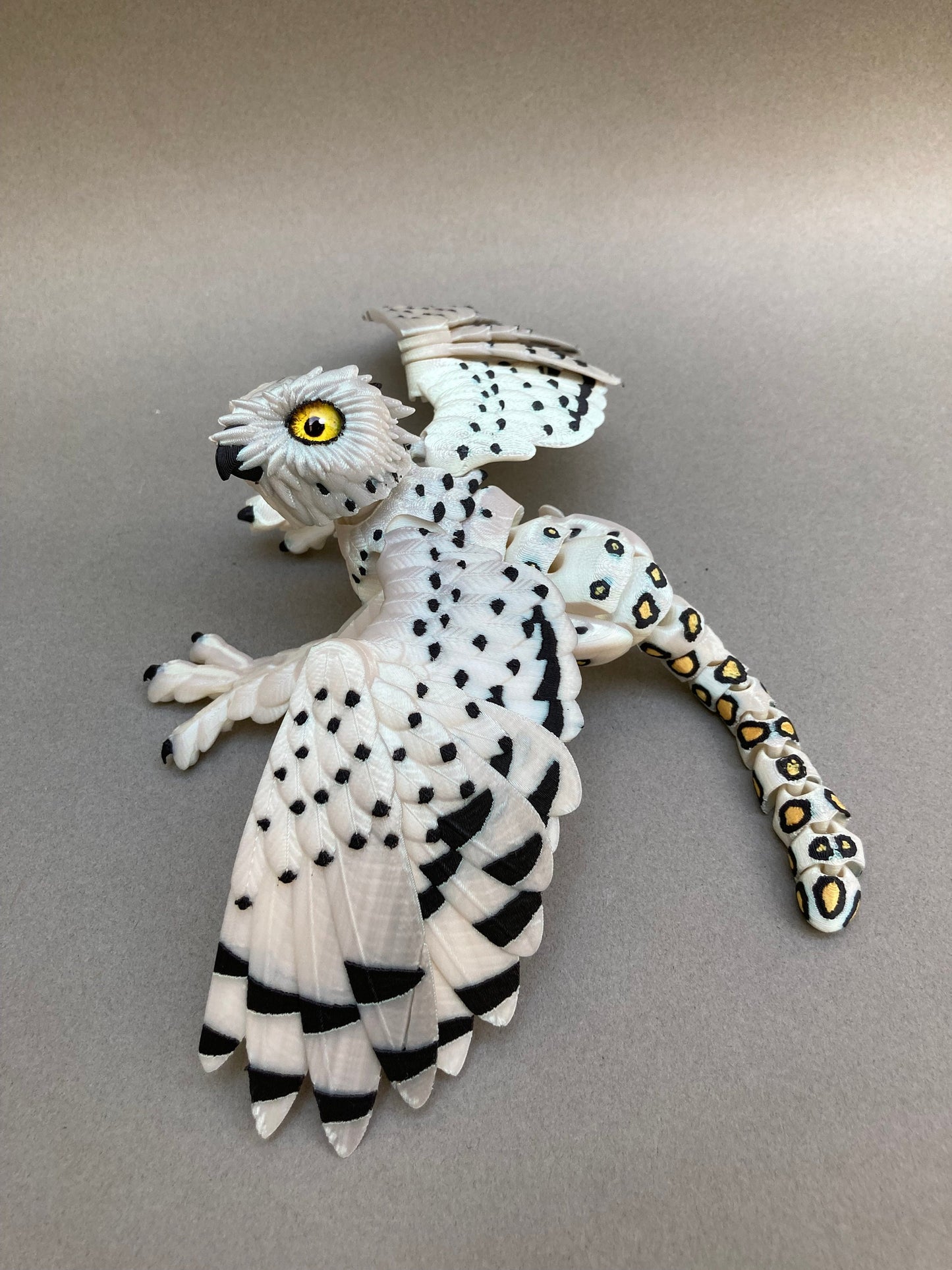 3D printed articulated Snow Gryphon fidget desk toy.