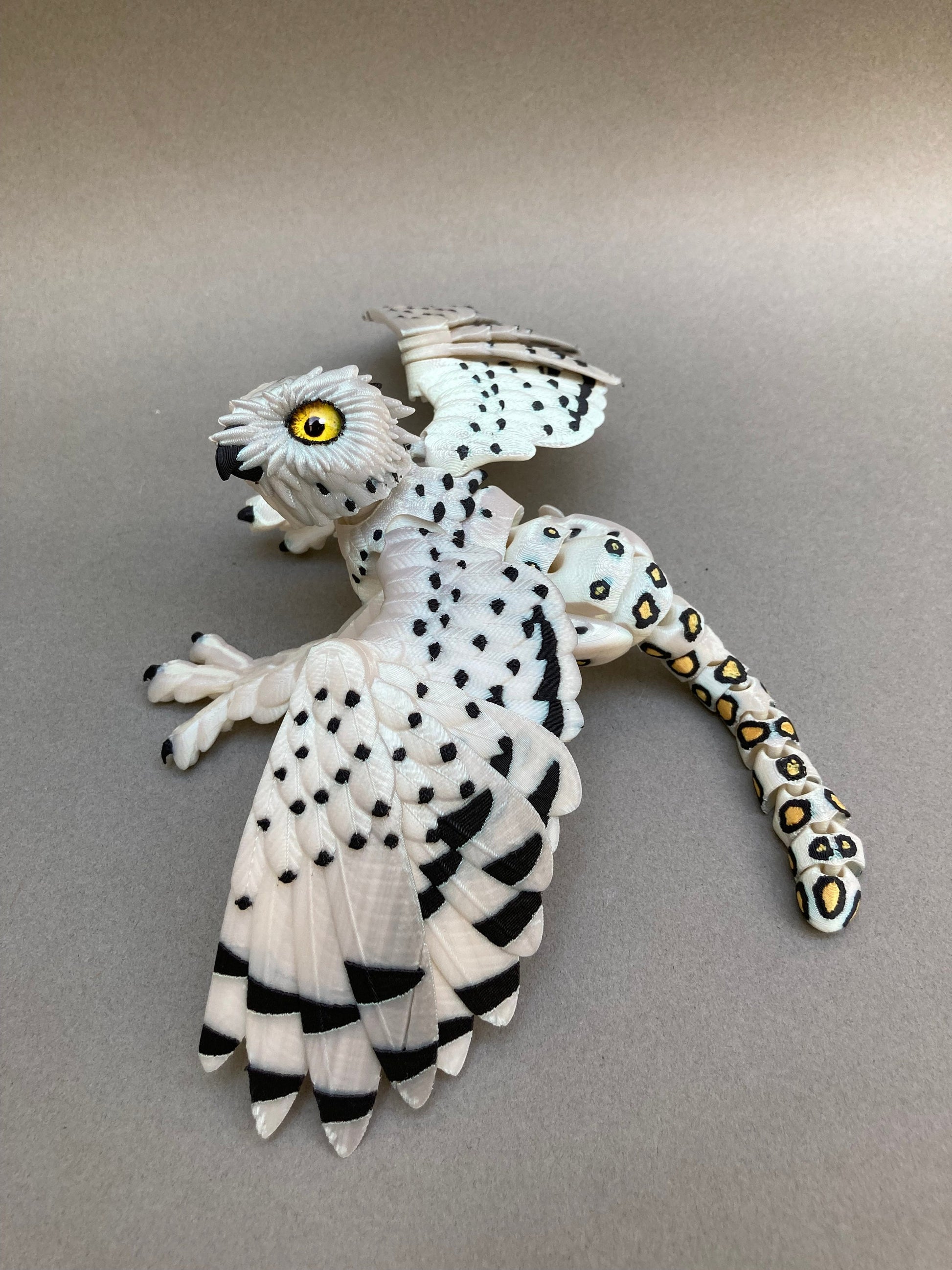 3D printed articulated Snow Gryphon fidget desk toy.