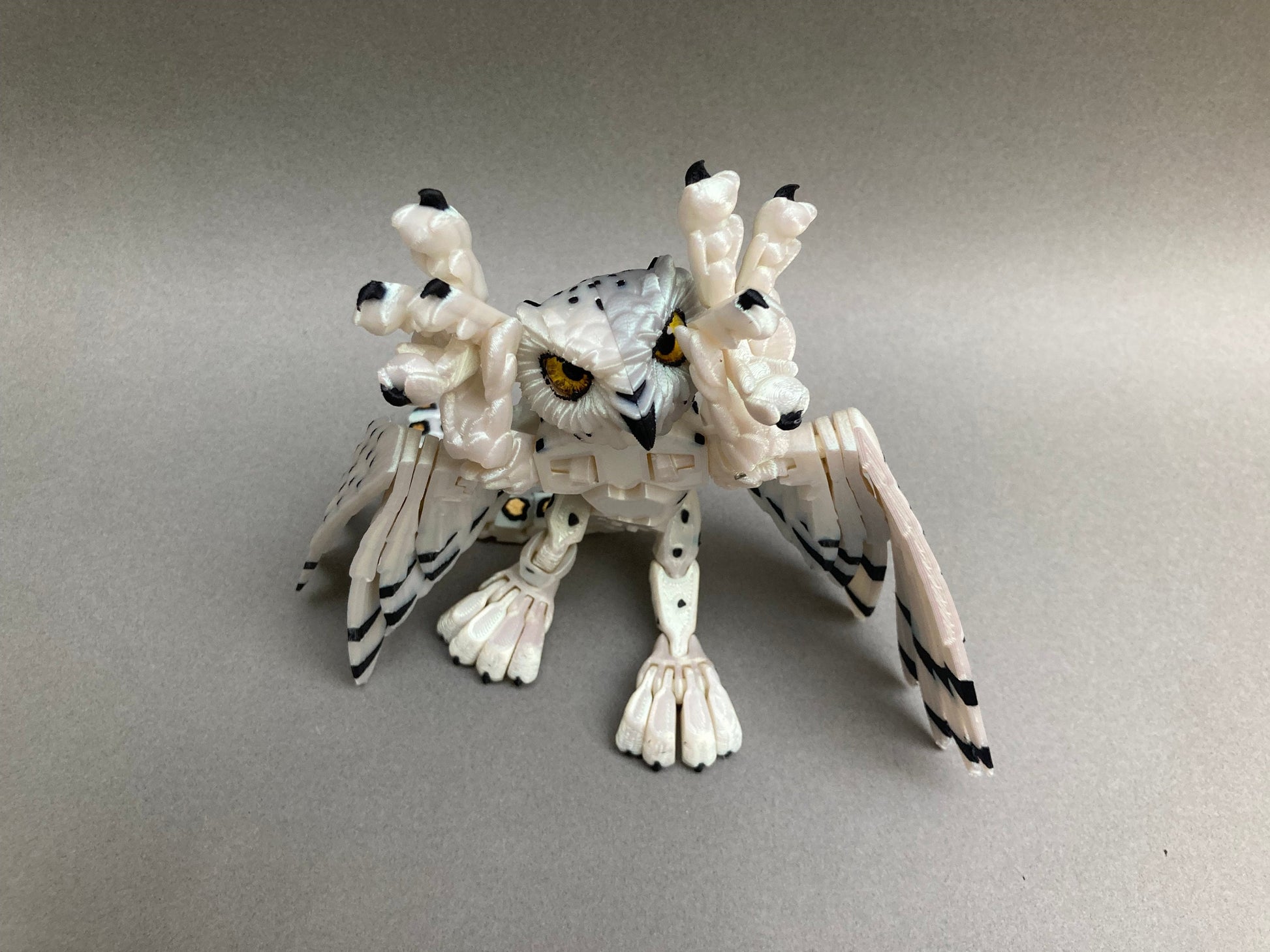 3D printed articulated Snow Gryphon fidget desk toy.